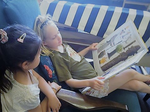 two children reading a book together